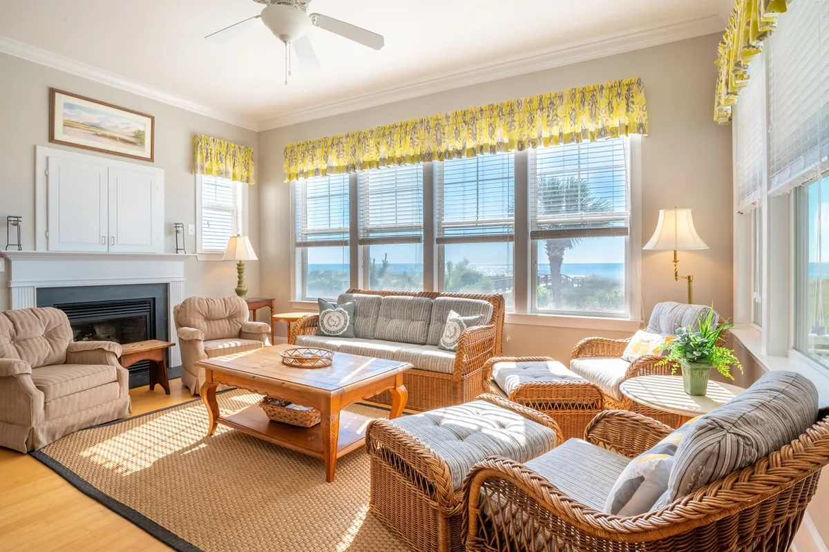 A welcoming living room with comfortable seating arranged to encourage conversation, large windows framing a panoramic ocean view, a wooden coffee table, and a stylish decorative lamp. The relaxed seating area is ideal for family gatherings, enjoying board games, or watching the sunset together through the expansive windows.
